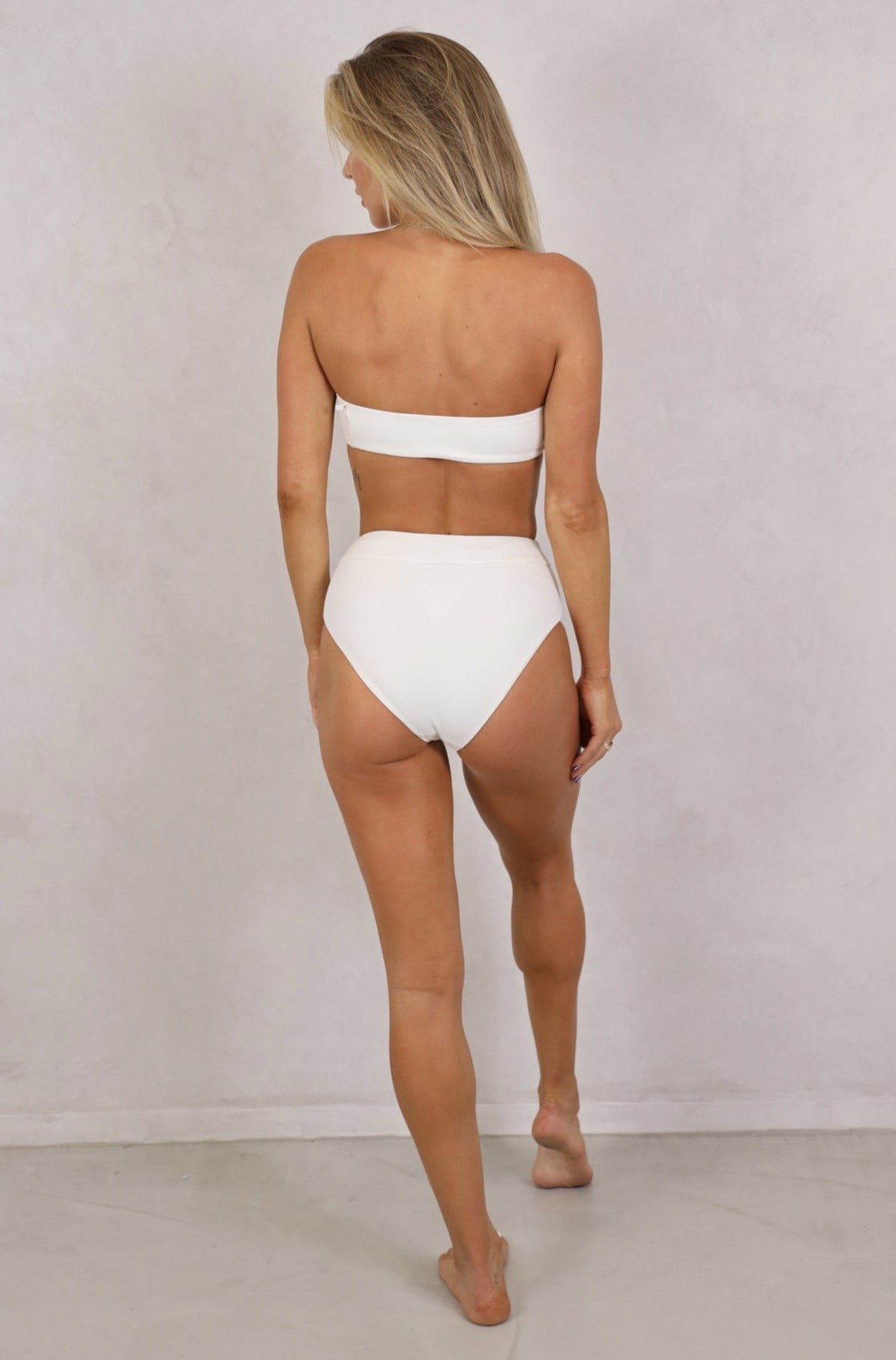 Shop seamless, ribbed strapless bandeau swimwear tops with removable front tie up knot. Women's Swimwear.White ribbed swimwear.Strapless Bandeau with removable padding. Bandeau Tops. White tops.Women's Bikinis and swimsuits. High waist full coverage bottoms to match.Free Shipping on Australian Orders over $100. Free Shipping to New Zealand on orders over $180.